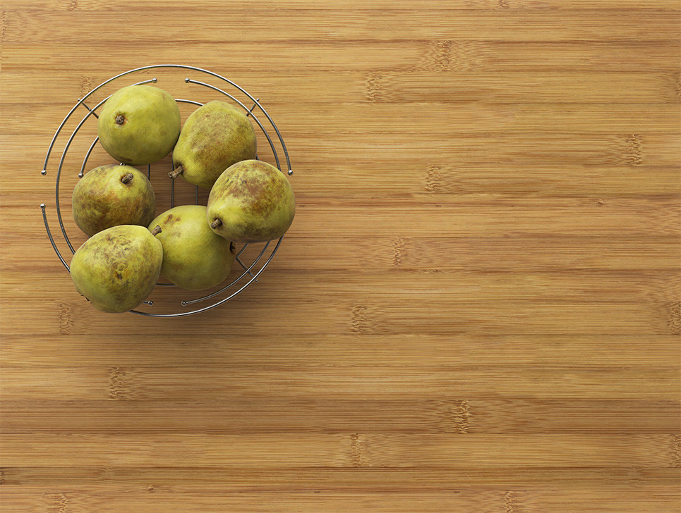 Pears in metal bowl on bamboo countertop